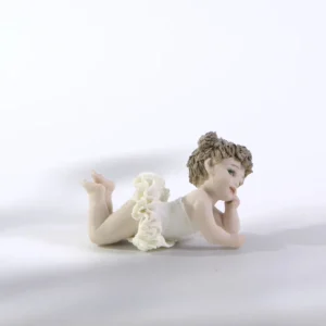 Statua in porcellana Ada Petipa, bimba ballerina in tutù di pizzo stesa a terra sulla pancia con due codine alte.