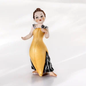 Statua in porcellana di piccola cantante in elegante abito giallo e grigio con microfono e chignon sulla nuca.