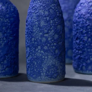 Dettaglio della superficie delle bottiglie con smalto che simula la schiuma del mare