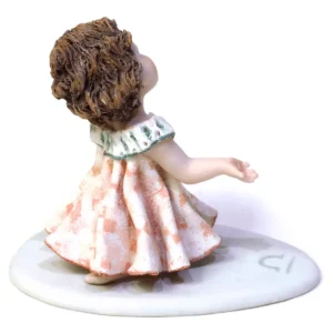 Statua in porcellana mini Bilancia con abito rosa e verde smeraldo, trina, braccia asimmetriche e base azzurra.