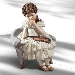 Statua in porcellana di ragazza seduta in poltrona con abito in tulle, violino e spartito.