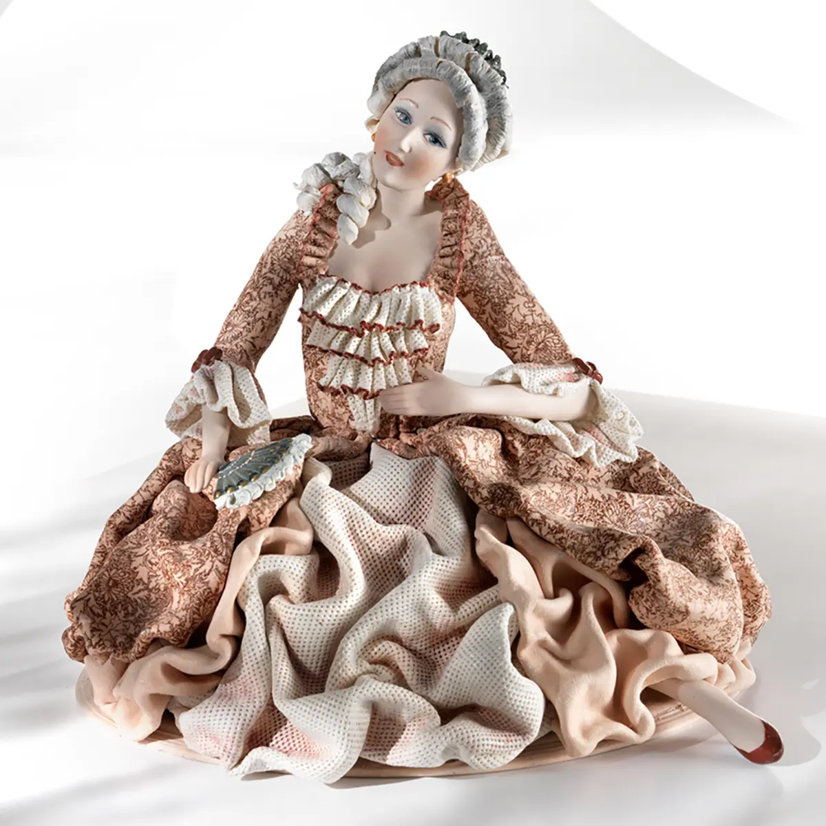 Statua in porcellana di dama veneziana del '700 seduta, in abito rosa con pizzo bianco e ventaglio blu.