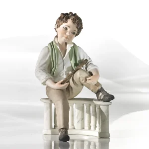 Statua in porcellana di ragazzo seduto su balaustra con camicia bianca, pantaloni marroni, sciarpa verde e flauto.