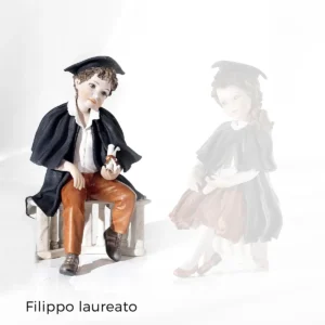 Statua in porcellana di ragazzo laureato con toga, tocco nero e pergamena, seduto su balaustra marmorizzata.