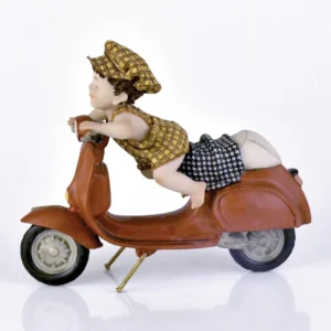Statua in porcellana con bimbo sulla Vespa rossa, in salopette e berretto pied de poule giallo e marrone.