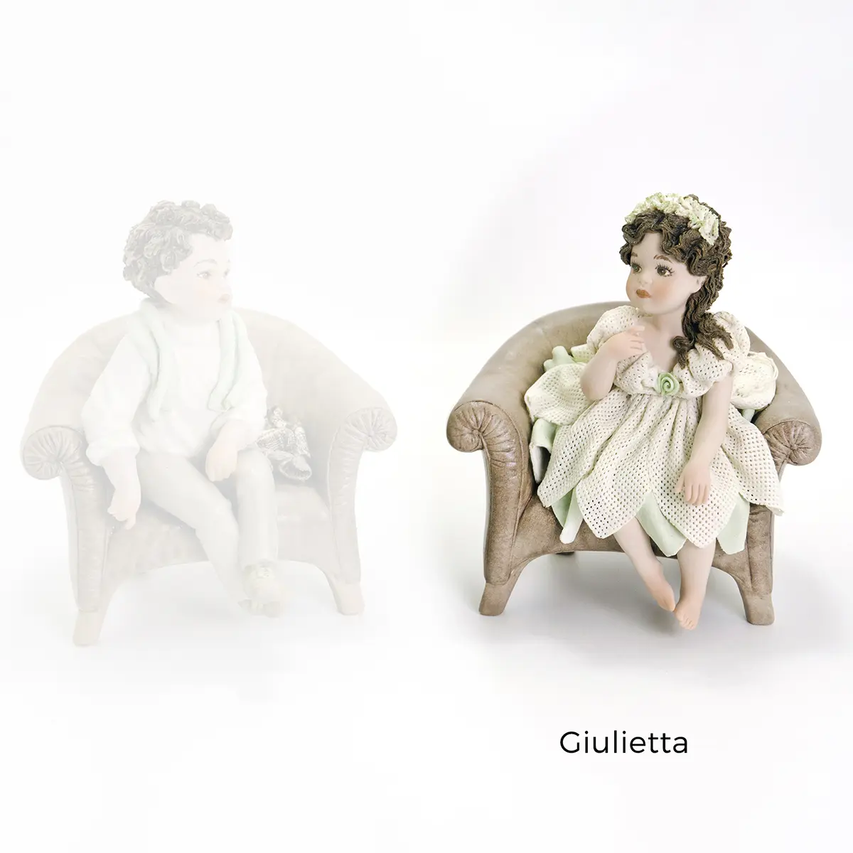 Statua in porcellana di Giulietta seduta in poltrona con abito in tulle verde acqua e coroncina.