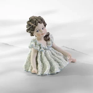 Statua in porcellana di bimba seduta con abito in pizzo bianco e azzurro e coda con rosellina.