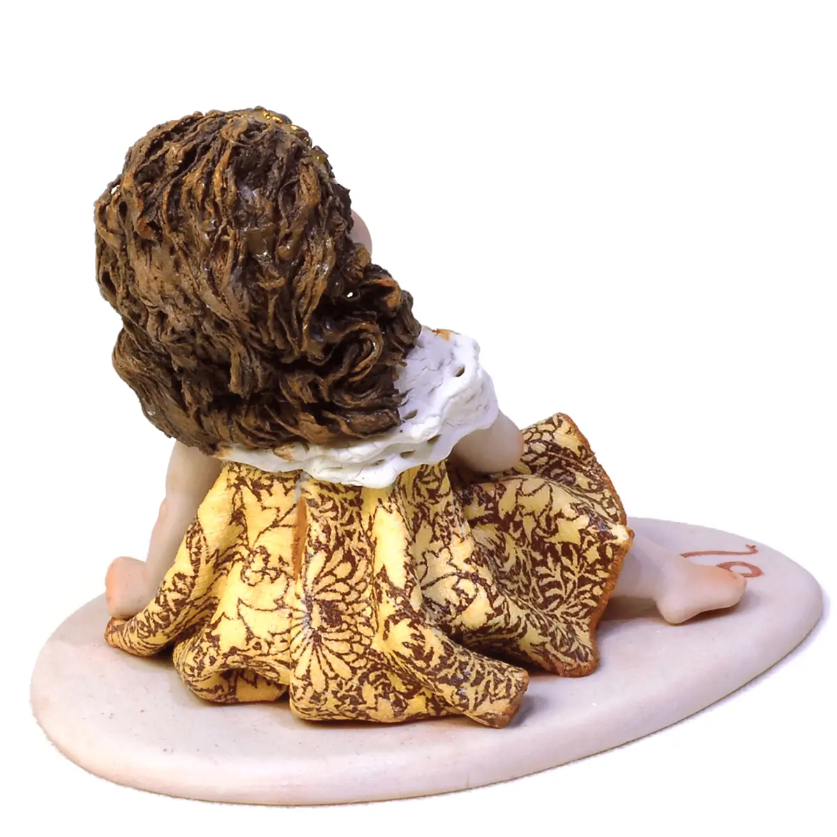 Statua in porcellana del Mini Leone Sibania con abito oro e ocra, fascia dorata e base rossa.