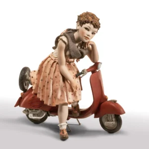 Statua in porcellana di ragazza seduta su Vespa rossa con gonna a pois rosa e maglia crema.