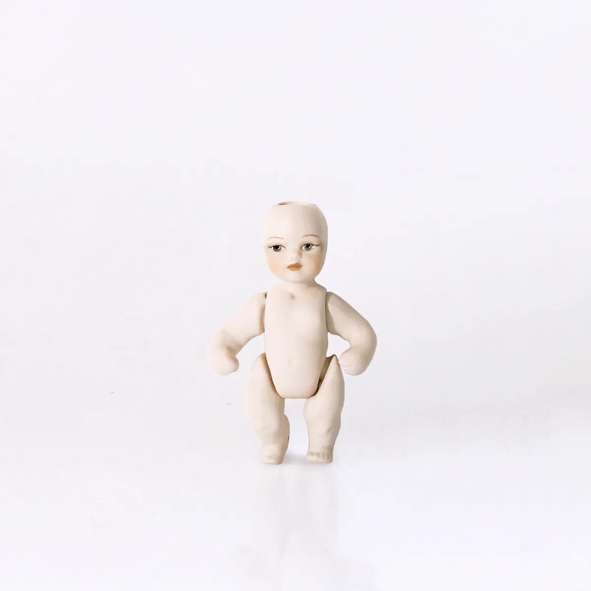 Bambolina in porcellana biscuit con braccia e gambe mobili, altezza 7 cm.