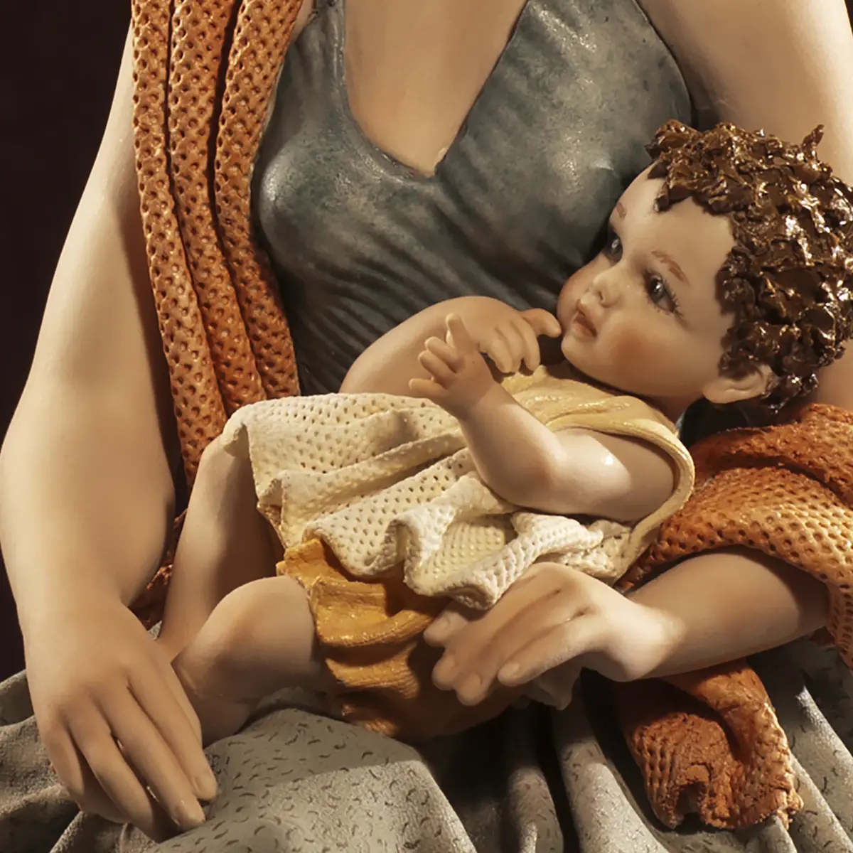 Statua in porcellana raffigurante una mamma in abito tortora e scialle salmone che tiene in braccio il suo bimbo.