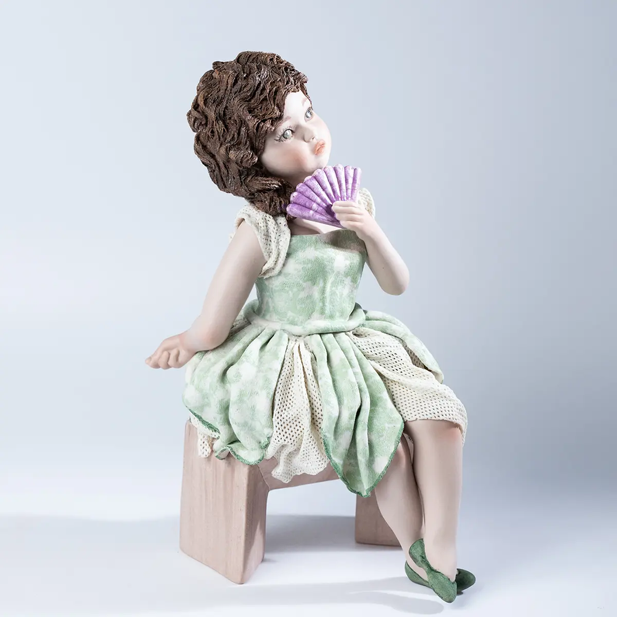 Statua in porcellana Olivia di Sibania con abito a corolla verde in tulle e fiori e ventaglio ametista.