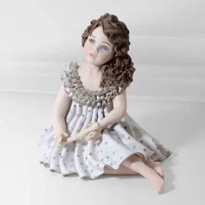 Statua in porcellana Pamina raffigurante una ragazza con grazioso abito azzurro e capelli poggiati su una spalla.