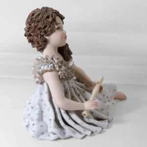 Statua in porcellana Pamina, ragazza in abito azzurro con capelli poggiati su una spalla.