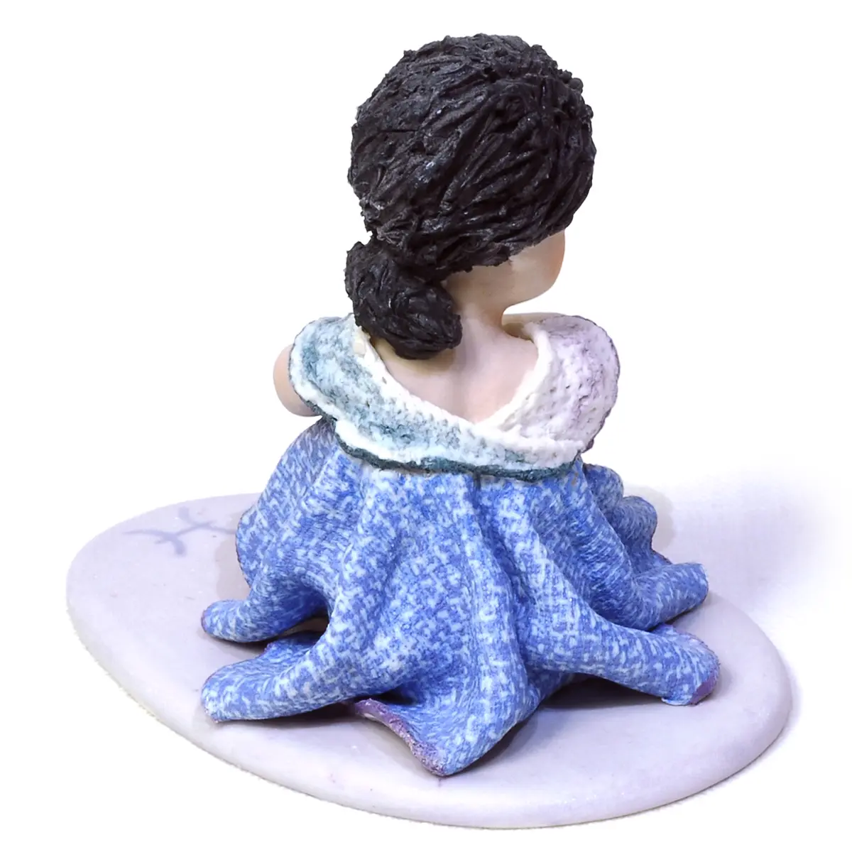 Statua in porcellana mini Pesci di Sibania, seduta con abito viola e celeste e dettagli in tulle bianco.