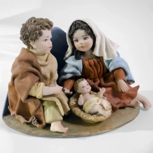 Presepe in porcellana con la Sacra Famiglia: Madonna in azzurro e rosso, San Giuseppe e Bambin Gesù sulla mangiatoia.