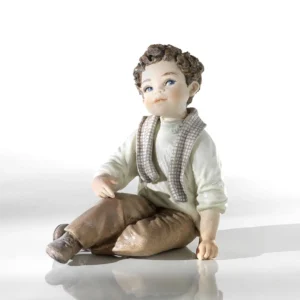 Statua in porcellana di bimbo seduto con maglioncino verde ghiaccio, pantaloni marroni e sciarpa a quadretti.